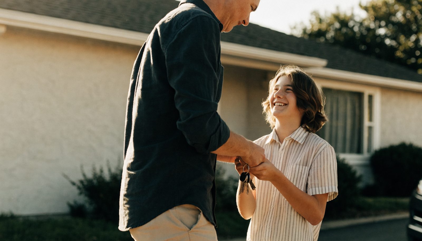 A parent handing keys to a teenage driver